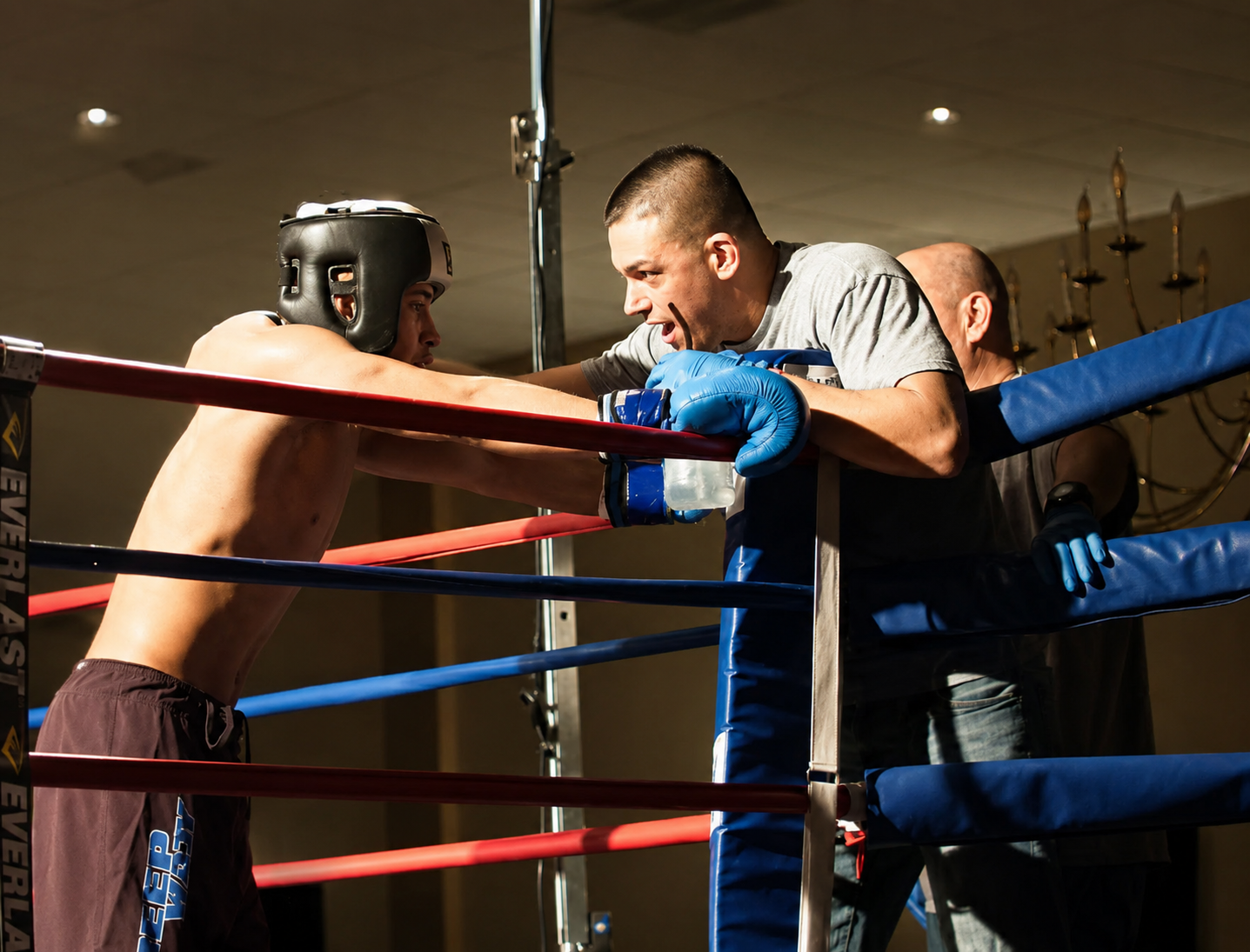 Muay Thai athlete receiving corner coaching between rounds during competition with a Deep Water BJJ coach in Harrisburg, PA.