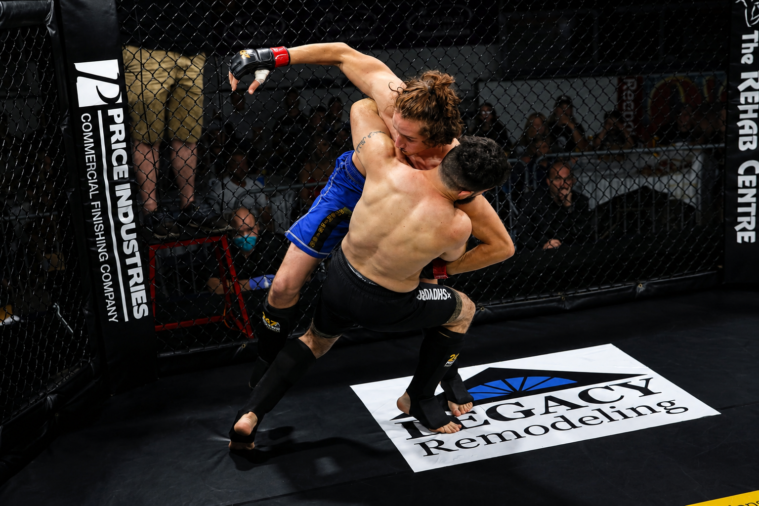 MMA Training in Harrisburg at Deep Water BJJ Two MMA athletes combining striking and grappling against the cage during competition.