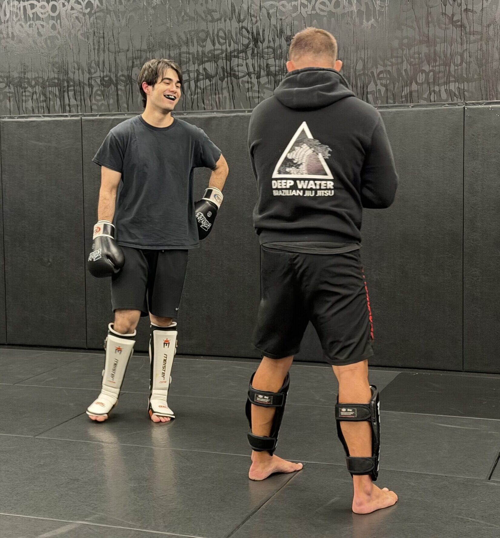 Adult striking student talking with a coach during training at Deep Water BJJ in Harrisburg