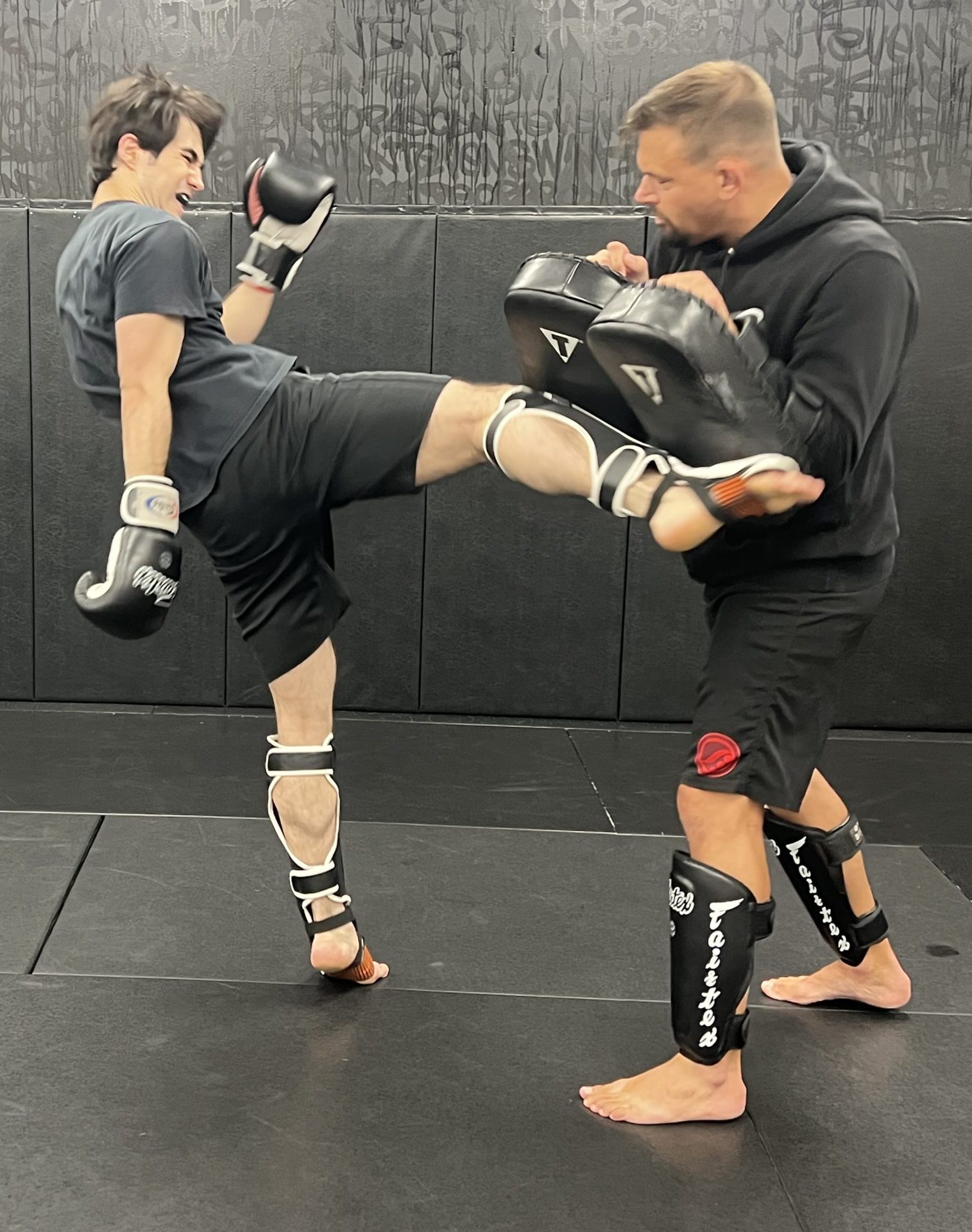 Student practicing a Muay Thai front kick on pads during coached training at Deep Water BJJ in Harrisburg, PA.