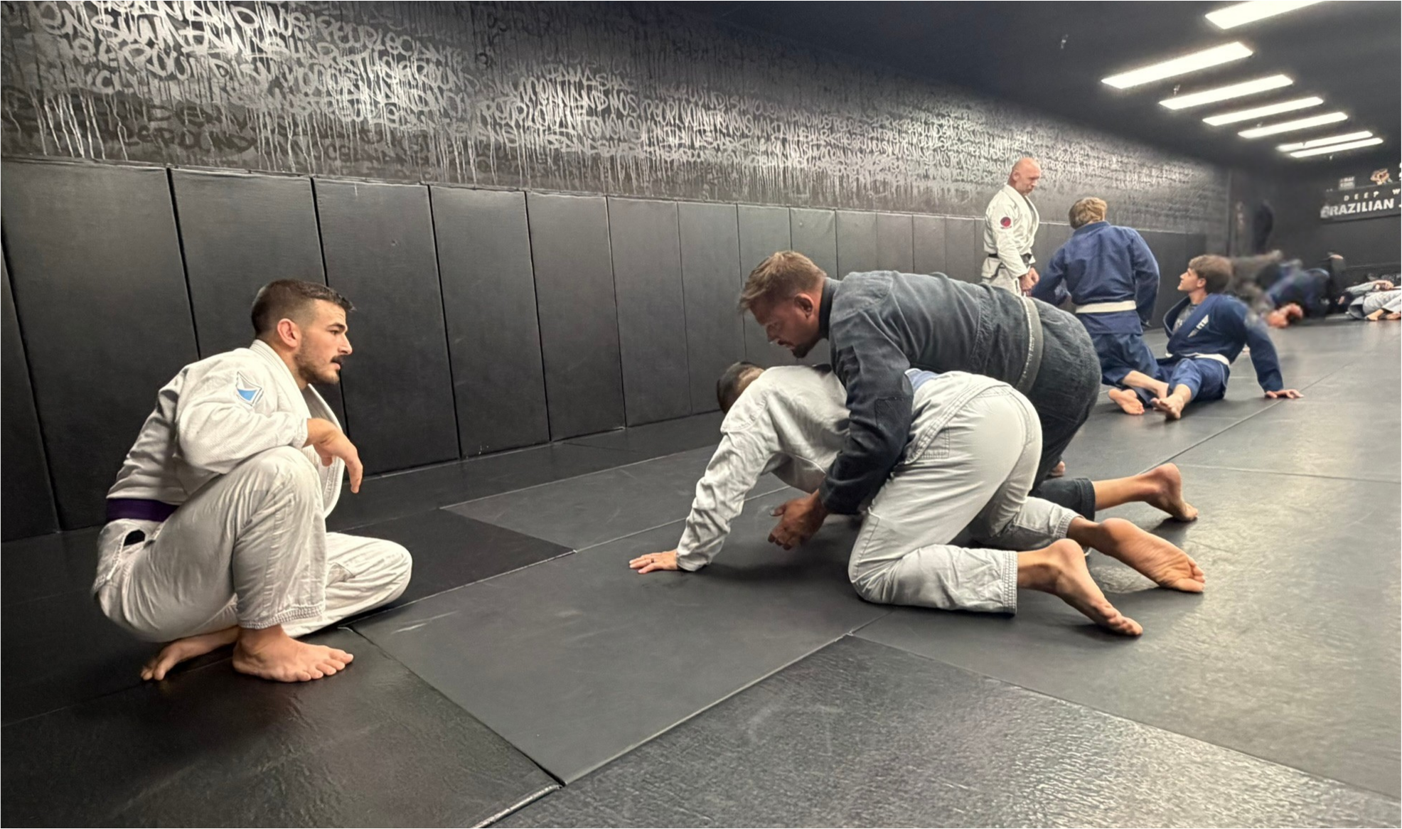 Deep Water BJJ coach helping students during a Brazilian Jiu-Jitsu class in Harrisburg, Pennsylvania.