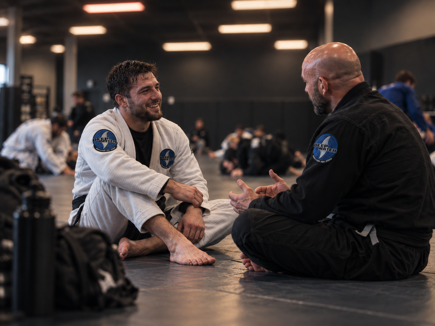 Martial arts student and instructor talking on the mats after Brazilian Jiu-Jitsu training